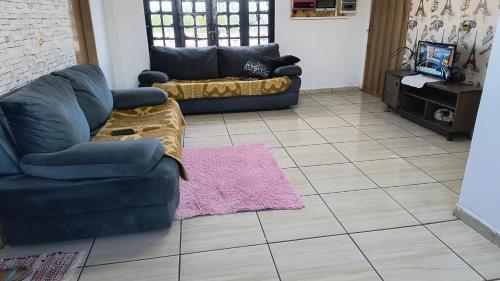 a living room with two couches and a pink rug at Pousada RC Q3 in Várzea Grande