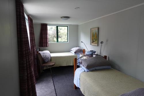a bedroom with two beds and a window at One Pigeon Takatu in Tawharanui