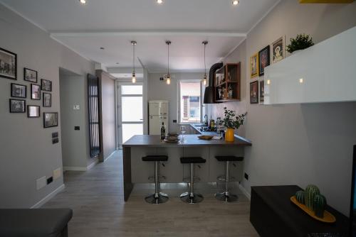 a kitchen with a counter and stools in a room at Centro-Appartamento SanMartino in Varese