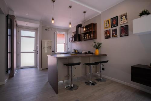 a kitchen with a counter and stools in it at Centro-Appartamento SanMartino in Varese