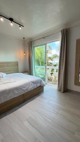 a bedroom with a bed and a large window at Hotel Juan Dolio in Juan Dolio