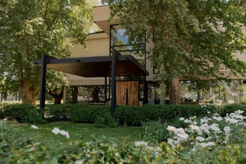 a building with a garden in front of it at La Urumpta Hotel, AKEN MIND in Río Cuarto