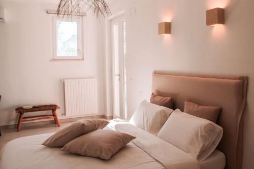 a bed with pillows in a room with a window at Dimora Caggione in Polignano a Mare