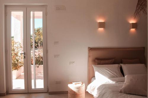 a bedroom with a bed and a sliding glass door at Dimora Caggione in Polignano a Mare
