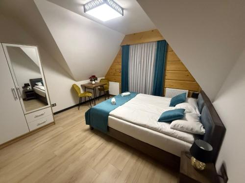 a bedroom with a large bed and a mirror at Willa Bafijówka in Groń