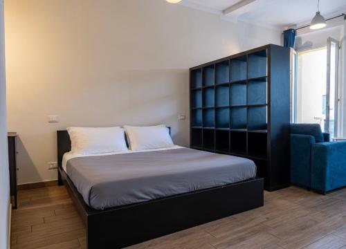 a bedroom with a large bed and a blue chair at Suite Cerchio 2 - City Center in Ravenna