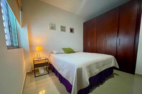 a small bedroom with a bed and a wooden cabinet at Charming Condo in Gaviotas Walk to Beach cafes, restaurants within Golden Zone in Mazatlán