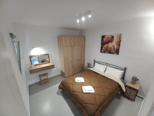 a bedroom with a bed with a wooden cabinet and a mirror at Velania House 1 in Filótion