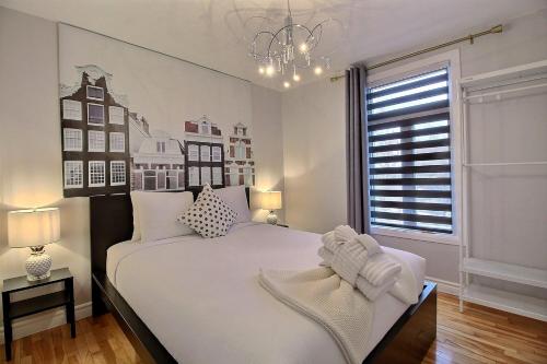 a bedroom with a large white bed and a window at Bluenose in Quebec City