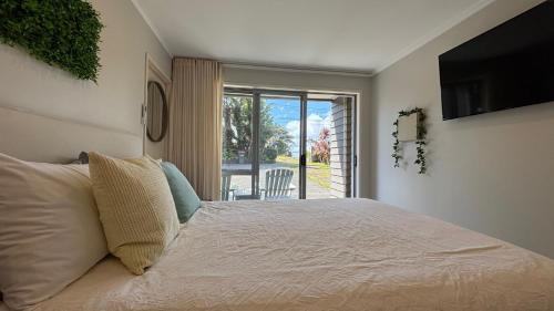 a bedroom with a bed and a large window at Peace and quiet on the beautiful North Shore in Auckland