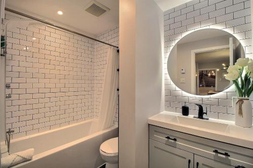 a white bathroom with a sink and a mirror at Bluenose in Quebec City