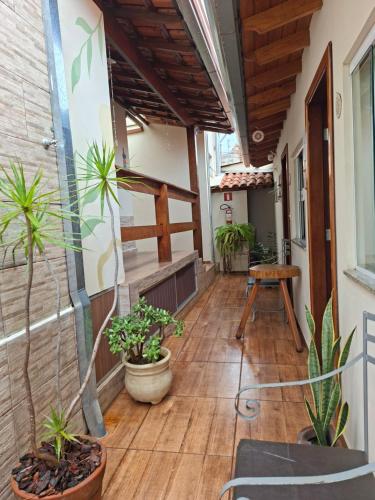 a porch with potted plants and a table at Suítes da Rô - hospedaria familiar diária e temporada in Varginha