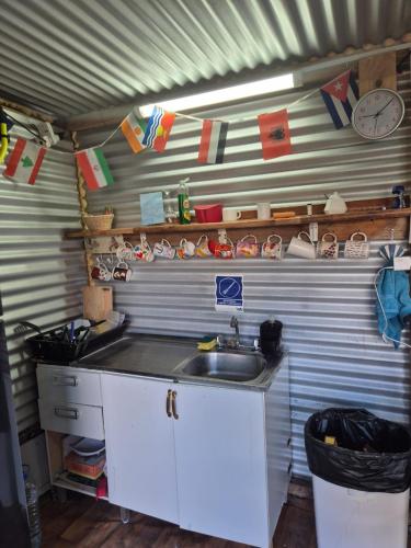 a kitchen with a sink and a clock on the wall at Alojamiento Emilia House y camping in Punta Arenas