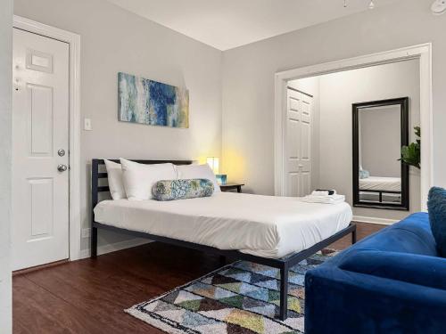 a bedroom with a bed with a mirror and a blue couch at Sunlit Studio with City Charm - Lunt studio rep in Chicago