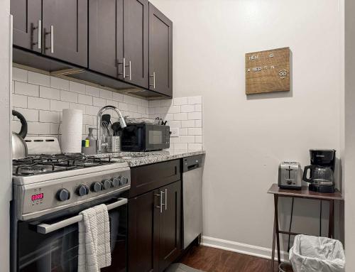 a kitchen with a stove and a microwave at Sunlit Studio with City Charm - Lunt studio rep in Chicago
