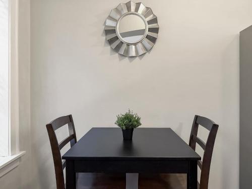 a black dining room table with a mirror on the wall at Sunlit Studio with City Charm - Lunt studio rep in Chicago