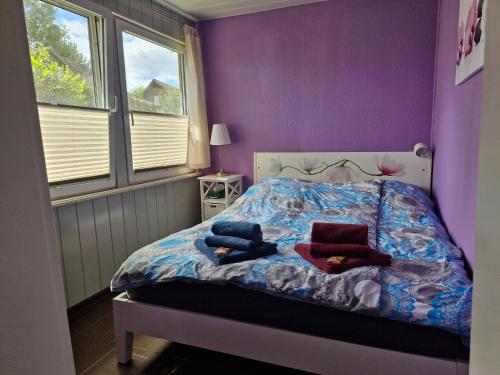 a bedroom with purple walls and a bed with pillows at Ferienhaus Marc in Göhren-Lebbin