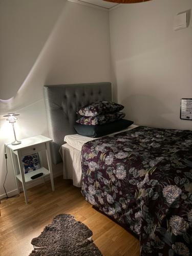 a bedroom with a bed and a table with a lamp at Solbacken 59 in Landvetter