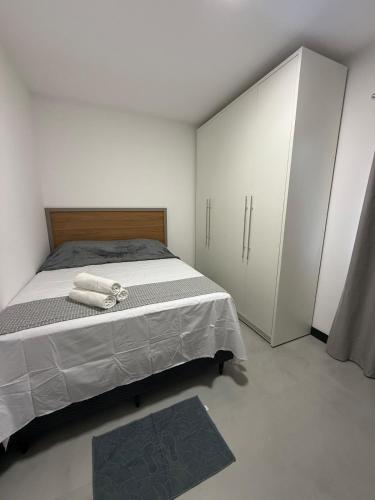 a bedroom with a bed with white cabinets and a rug at Brisa Mar Prime in Porto Seguro