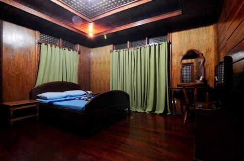 1 dormitorio con 1 cama y cortina verde en Pems Pension and Restaurant, en Taytay