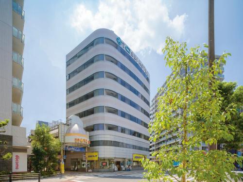 a tall blue building with a sign on it at Tosei Hotel Cocone Kamata in Tokyo