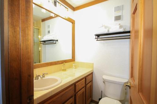 a bathroom with a sink and a toilet and a mirror at Mountainback 116 LoftCorner in Mammoth Lakes