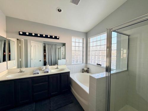 a bathroom with two sinks and a tub and a shower at Oasis pool house, optional pool heater in Las Vegas