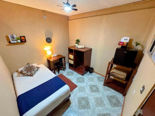 a small bedroom with a bed and a small table at Estancia Punto Coliving Estadio in Morelia