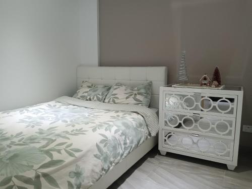a bedroom with a bed and a night stand at The Cosy Beach Nook 2BR Near Airport & Beach in Sydney