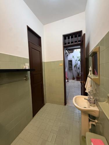 a bathroom with a sink and a toilet and a door at Casa Tierra Libre in Cali