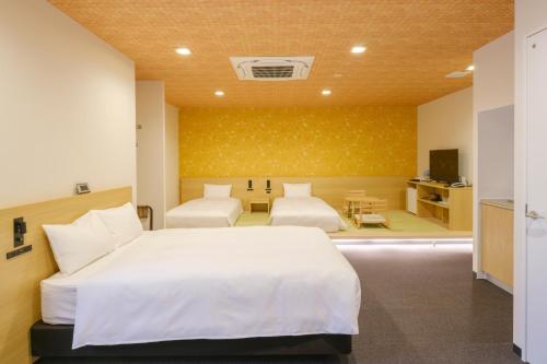a hotel room with two beds and a table at Tosei Hotel Cocone Kamata in Tokyo
