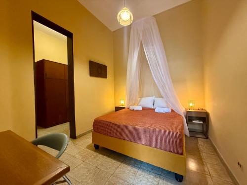 a bedroom with a bed with a window and a table at Casa Tierra Libre in Cali