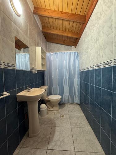 a bathroom with a sink and a toilet and a mirror at Hostal Asuncion in Arica