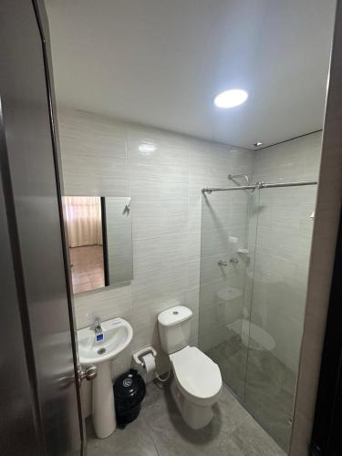 a bathroom with a toilet and a glass shower at Hotel vizion in Ibagué