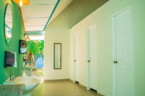a bathroom with a sink and a white door at Selina Venao Beach West in Playa Venao