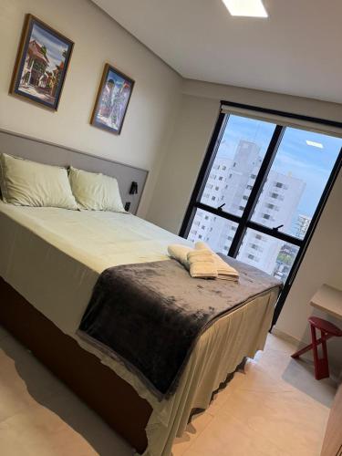 a bedroom with a large bed with a large window at Apartamento Exclusivo com Vista Mar no Number One Flat in São Luís