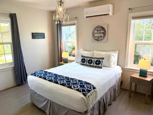 a bedroom with a large bed and two windows at Cozy Farm House with River access in Three Rivers