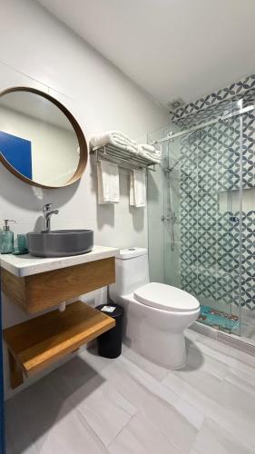 a bathroom with a toilet and a sink and a shower at Hotel Juan Dolio in Juan Dolio
