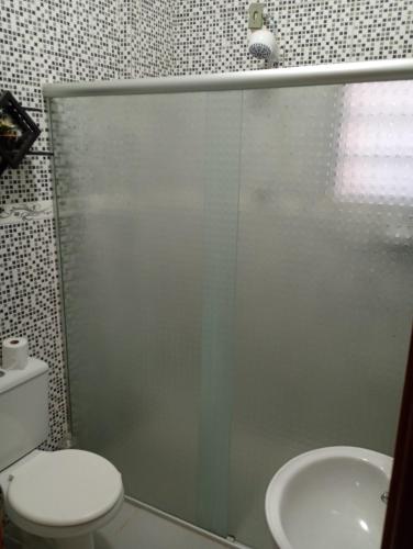 a bathroom with a shower and a toilet and a sink at Casa sobrado in Alegrete