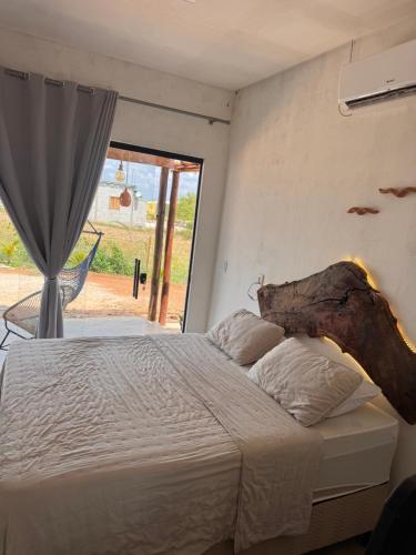 a bedroom with a bed and a large window at Chalé Mansões do Rio in Casa Nova