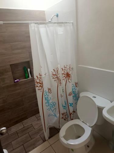 a bathroom with a toilet and a shower curtain at Casa Roque in El Balcón