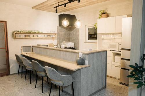 a kitchen with a bar with stools in it at garden villa 月灯tsukibi in Shiraoi