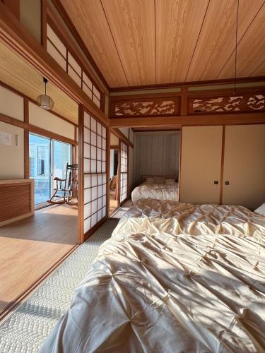 a bedroom with a large bed with a wooden ceiling at garden villa 月灯tsukibi in Shiraoi
