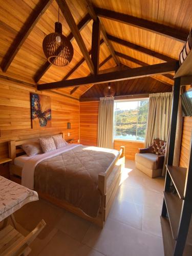 a bedroom with a bed in a wooden room at Chalé do Lago Urupema SC in Urupema