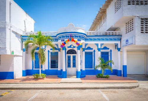 a blue and white building with palm trees in front at Casa Caribe Colonial in Barranquilla
