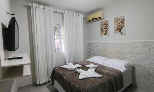 a bedroom with a bed with two towels on it at Murilo House - Apart-hotel completo e privativo in São José