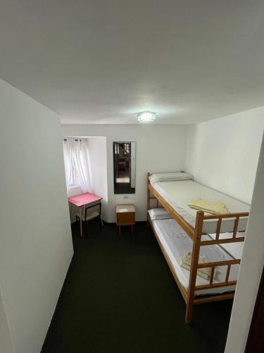a small room with two bunk beds and a desk at Hospedaje Buen Descanso in Paso de los Libres