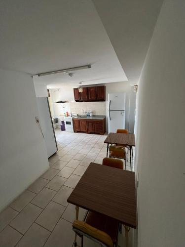 a kitchen with a table and chairs and a refrigerator at Hospedaje Buen Descanso in Paso de los Libres
