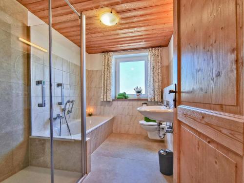 ein Badezimmer mit Badewanne, Toilette und Waschbecken in der Unterkunft Oachkatzl in Wildsteig