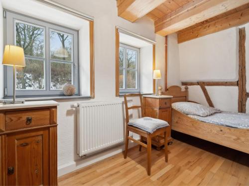 a bedroom with a bed and a desk and windows at Kaffeemühle Hamma II in Heringen